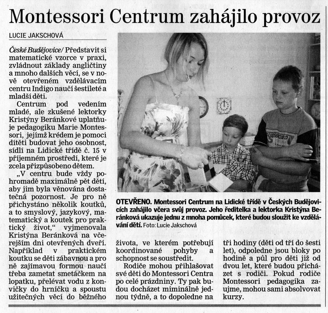 Žena s dětmi v Montessori centru, děti pracují u stolu s učebními materiály v místnosti.